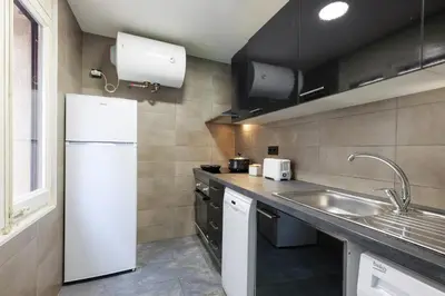 a kitchen with a white refrigerator and a sink at matarolux21 in Mataró