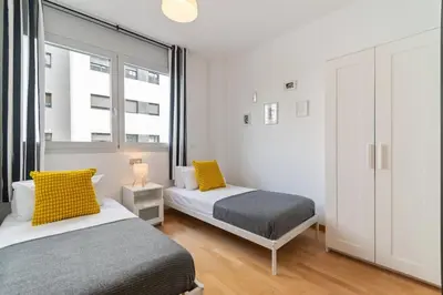 a bedroom with two beds and a window at Modern Spacious 3-Bedroom Apt with Pool near Beach in Barcelona