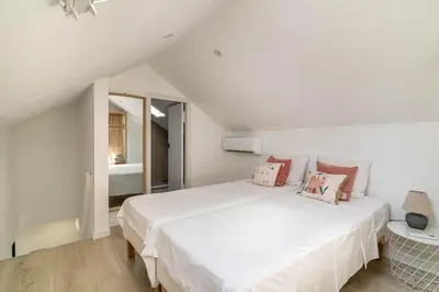 a white bedroom with a large white bed with pillows at The Sweet House - BBQ y piscina in Sant Cugat del Vallès