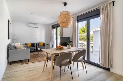 a kitchen and living room with a table and chairs at The Sweet House - BBQ y piscina in Sant Cugat del Vallès