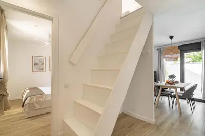 a white staircase in a room with a table at The Sweet House - BBQ y piscina in Sant Cugat del Vallès