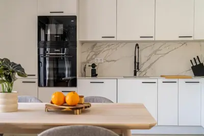 a kitchen with white cabinets and a table with oranges at The Sweet House - BBQ y piscina in Sant Cugat del Vallès
