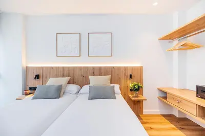 a bedroom with two beds and a tv at Brabo Apartments in Hospitalet de Llobregat