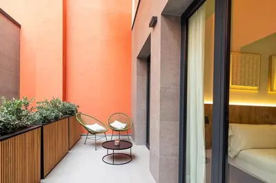 two chairs and a bed on a balcony at Brabo Apartments in Hospitalet de Llobregat