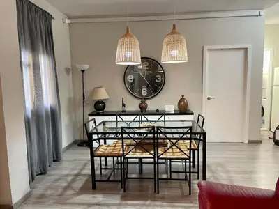 a dining room with a table and a clock on the wall at Apartamento vacaciones Barcelona in Barcelona