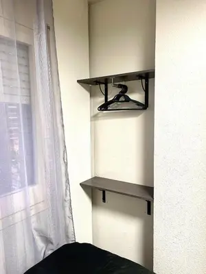 a shelf in the corner of a room with a window at Apartamento vacaciones Barcelona in Barcelona