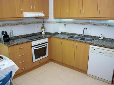a kitchen with a sink and a stove top oven at Winahost El balcón al mar de Cubelles in Cubelles