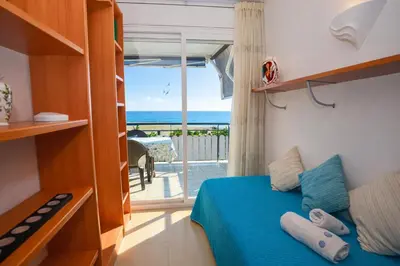 a bedroom with a bed and a view of the ocean at Winahost El balcón al mar de Cubelles in Cubelles