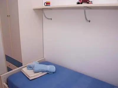 a bed in a room with a blue towel on it at Winahost El balcón al mar de Cubelles in Cubelles