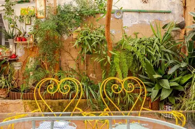 a group of yellow metal chairs in a garden at Vintage home in Barcelona