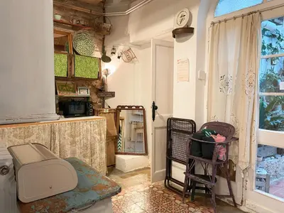 a bathroom with a toilet and a mirror and a window at Vintage home in Barcelona