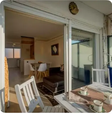 a living room with a sliding glass door with a table and chairs at Ocean View Sunny Beach Apartment Castelldefels in Castelldefels
