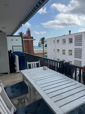 a table and chairs on a balcony with the beach at Ocean View Sunny Beach Apartment Castelldefels in Castelldefels
