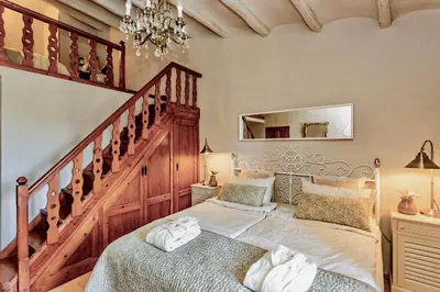 a bedroom with a large bed and a staircase at Montrural in Castellví de la Marca