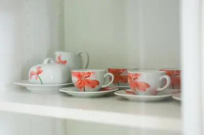 a group of cups and saucers on a shelf at ApartEasy - Lovely Atic in Barcelona in Barcelona