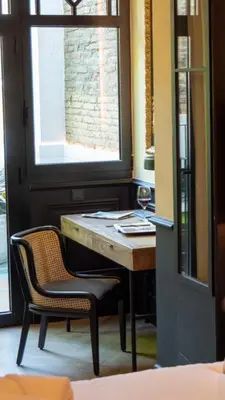 a table and two chairs in a room with a window at Boada Riera - The RoomsbyReini in Terrassa