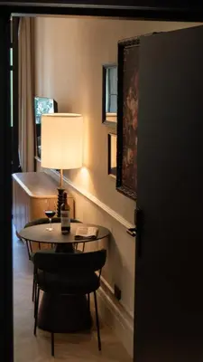 a room with a table with a lamp and a chair at Boada Riera - The RoomsbyReini in Terrassa