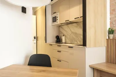 a kitchen with a table and a black chair at GuestReady - ARIQUS Apartments in Barcelona