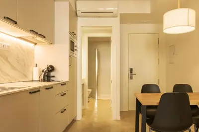 a kitchen and dining room with a table and chairs at GuestReady - ARIQUS Apartments in Barcelona