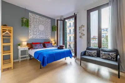 a bedroom with a bed and a couch and a window at Studio Premium en Sants a 15' Bcn Centro y Fira Bcn in Barcelona