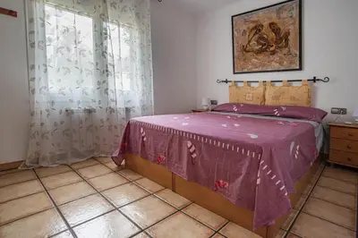 a bedroom with a bed with a purple blanket at Cal Sopas in Collbató