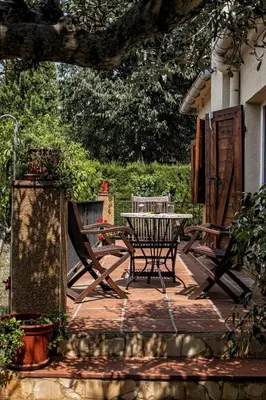 a wooden deck with a table and chairs on it at Cal Sopas in Collbató
