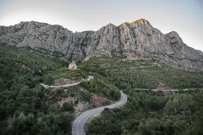 a winding road in front of a mountain at Cal Sopas in Collbató