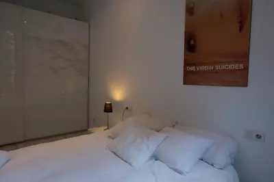 a white bed with white pillows in a bedroom at Roger De Lluria Design Apartment in Barcelona