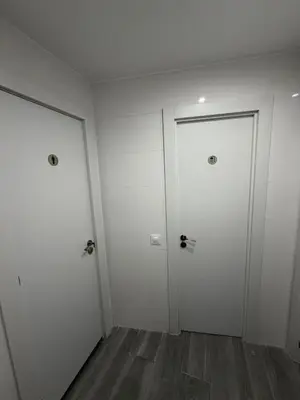 two white doors in a room with wood floors at Hostel Hock Residences in Hospitalet de Llobregat
