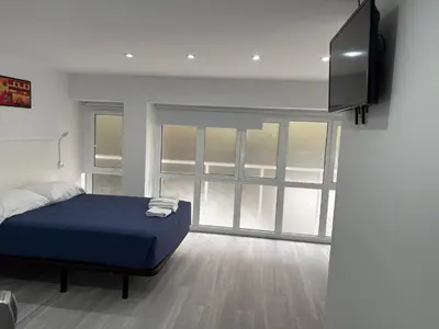 a bedroom with a bed and a flat screen tv at Hostel Hock Residences in Hospitalet de Llobregat