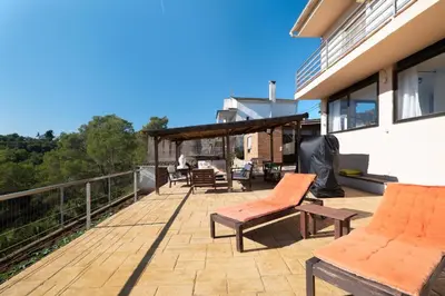 a deck with chairs and a grill on a house at Mima House with Pool in Canyelles