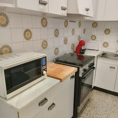 a kitchen with a microwave and a stove at Vivalidays Andrea - Pineda de Mar in Pineda de Mar