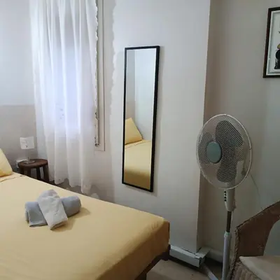 a bedroom with a fan next to a bed and a mirror at Vivalidays Andrea - Pineda de Mar in Pineda de Mar