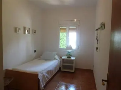 a small bedroom with a bed and a window at Casa de pueblo con jardín in Premiá de Mar