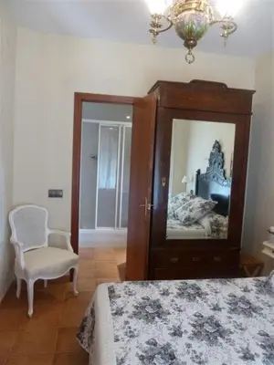 a bedroom with a bed and a mirror and a chair at Casa de pueblo con jardín in Premiá de Mar