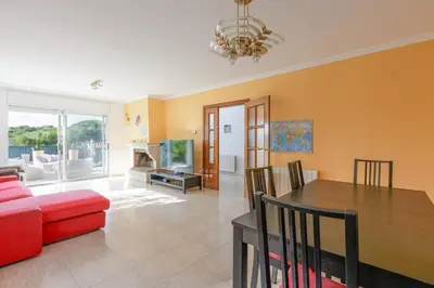 a living room with a red couch and a table at Fantástica casa en alquiler con piscina en Vilanova i la Geltrú in Vilanova i la Geltrú