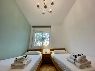 two twin beds in a room with a window at Amazing apartment close to the beach Eli by Hl in Vilanova i la Geltrú