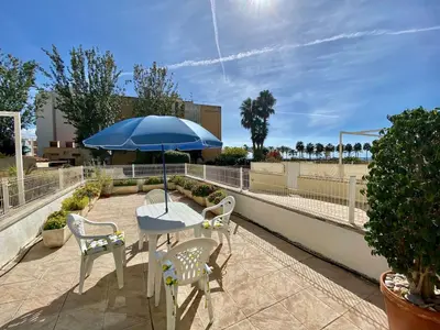 a table and chairs with an umbrella on a patio at Amazing apartment close to the beach Eli by Hl in Vilanova i la Geltrú