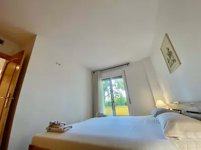 a white bedroom with two beds and a window at Amazing apartment close to the beach Eli by Hl in Vilanova i la Geltrú