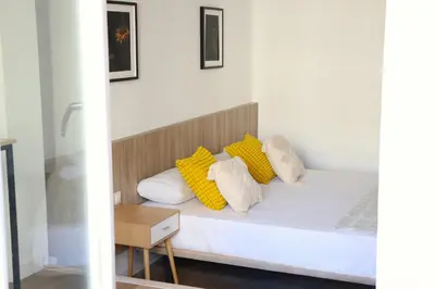 a bedroom with a bed with yellow and white pillows at Hamilton Suites in Barcelona
