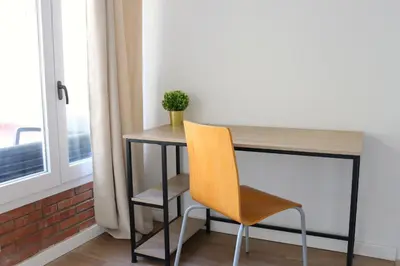 a desk with a yellow chair next to a window at Hamilton Suites in Barcelona