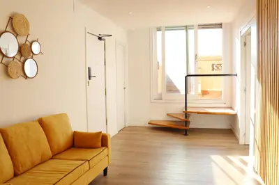 a living room with a couch and a window at Hamilton Suites in Barcelona