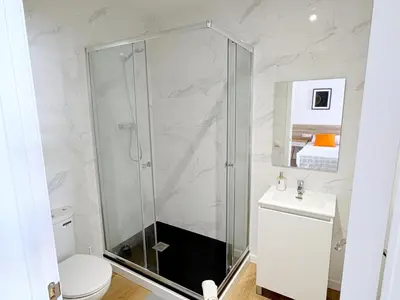 a bathroom with a shower and a toilet and a sink at Hamilton Suites in Barcelona