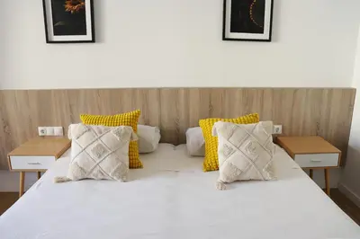 a bedroom with a bed with yellow and white pillows at Hamilton Suites in Barcelona