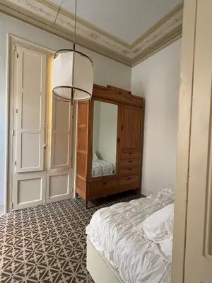 a bedroom with a bed and a dresser and a mirror at Ca La Manso in Sitges