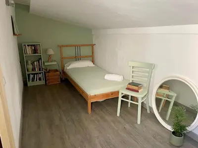 a bedroom with a bed and a chair and a mirror at Mar de Flores in Vilassar de Mar