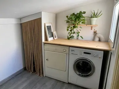 a laundry room with a washing machine and a shelf at Mar de Flores in Vilassar de Mar