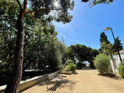 a park bench sitting next to a tree at Mar de Flores in Vilassar de Mar