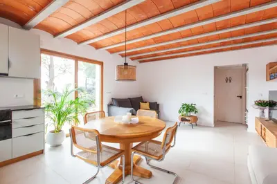 a kitchen and living room with a wooden table and chairs at Aldana accommodation in the middle of nature in Molins de Rei