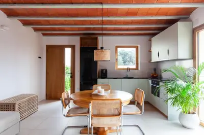a kitchen and dining room with a wooden table and chairs at Aldana accommodation in the middle of nature in Molins de Rei